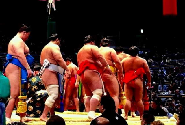 Rikishi with Mawashi walking around the dohyo