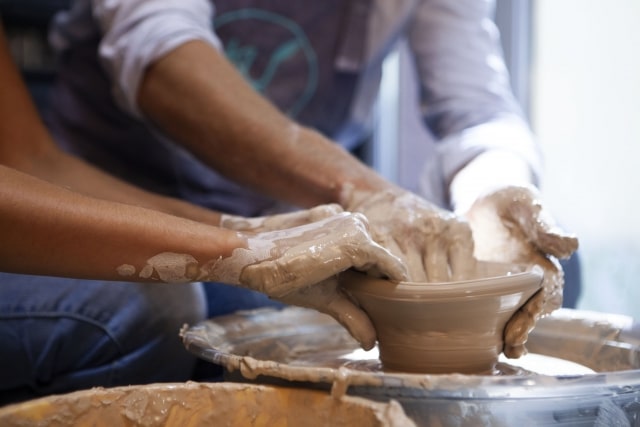 shaping a pottery with wheel
